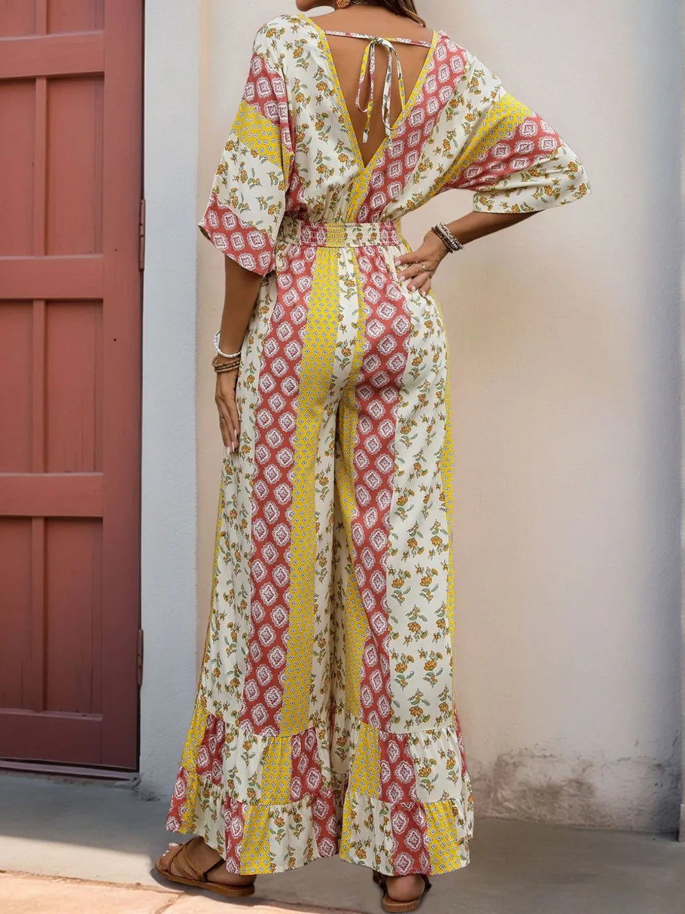 Backless multicolor printed jumpsuit with V-neck, tie waist, ruffled wide legs