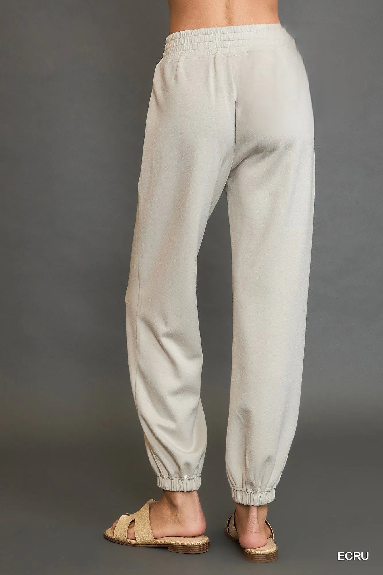 Ecru drawstring jogger pants, front view with elastic waistband and tapered legs