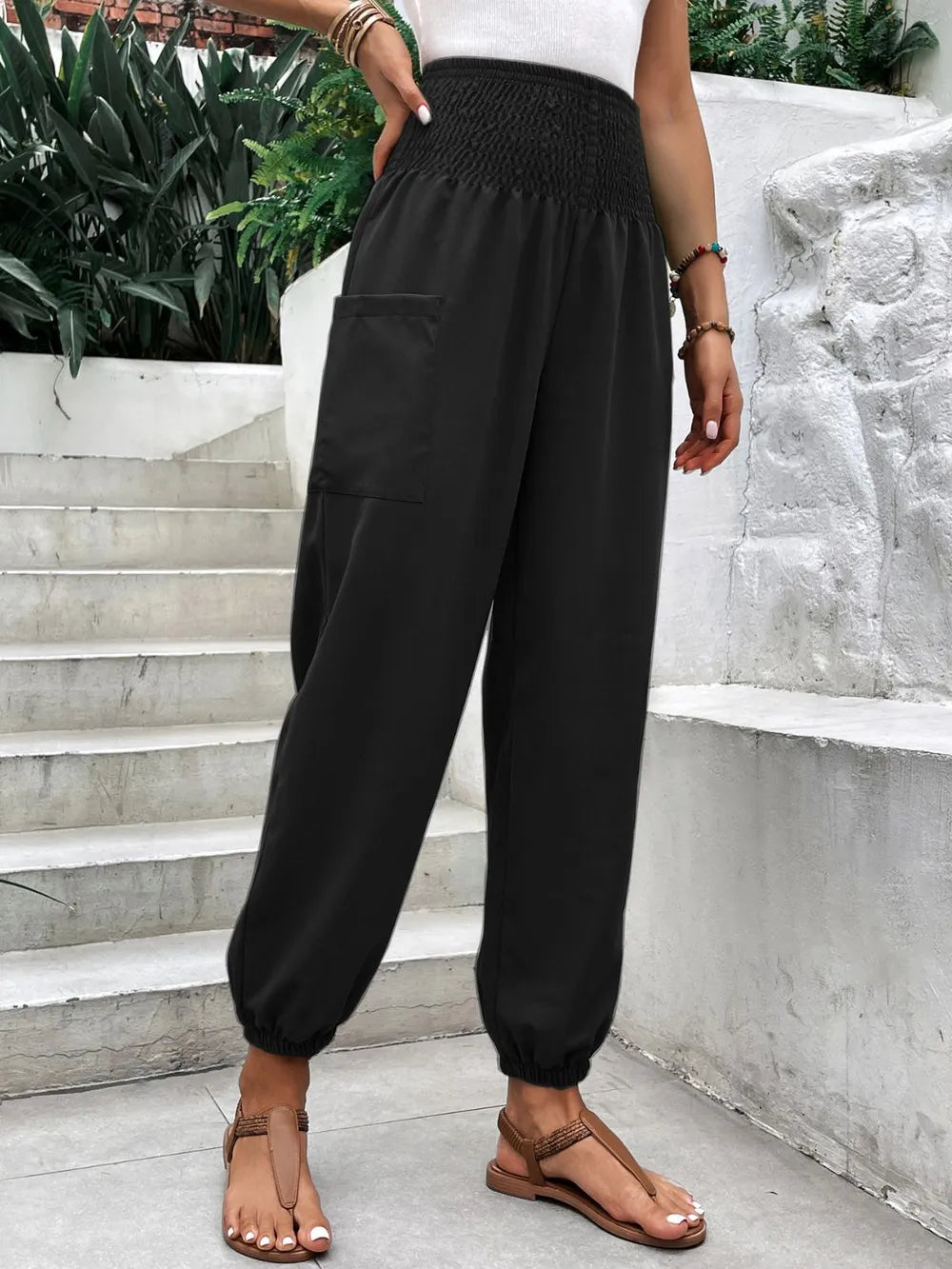 Black smocked high-rise joggers with side pockets and gathered ankle cuffs