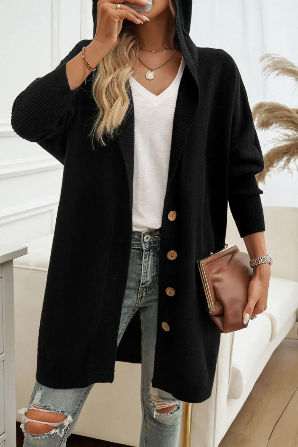 Black hooded button-up cardigan with long sleeves and front button closure.