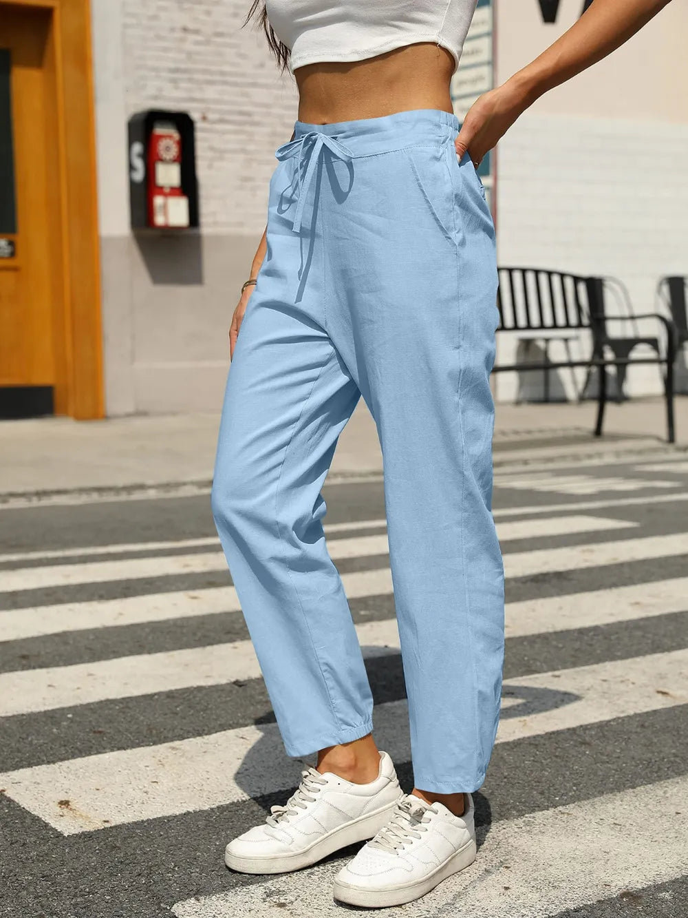 Pastel blue elastic waist tapered pants with drawstring ties, ankle-length fit