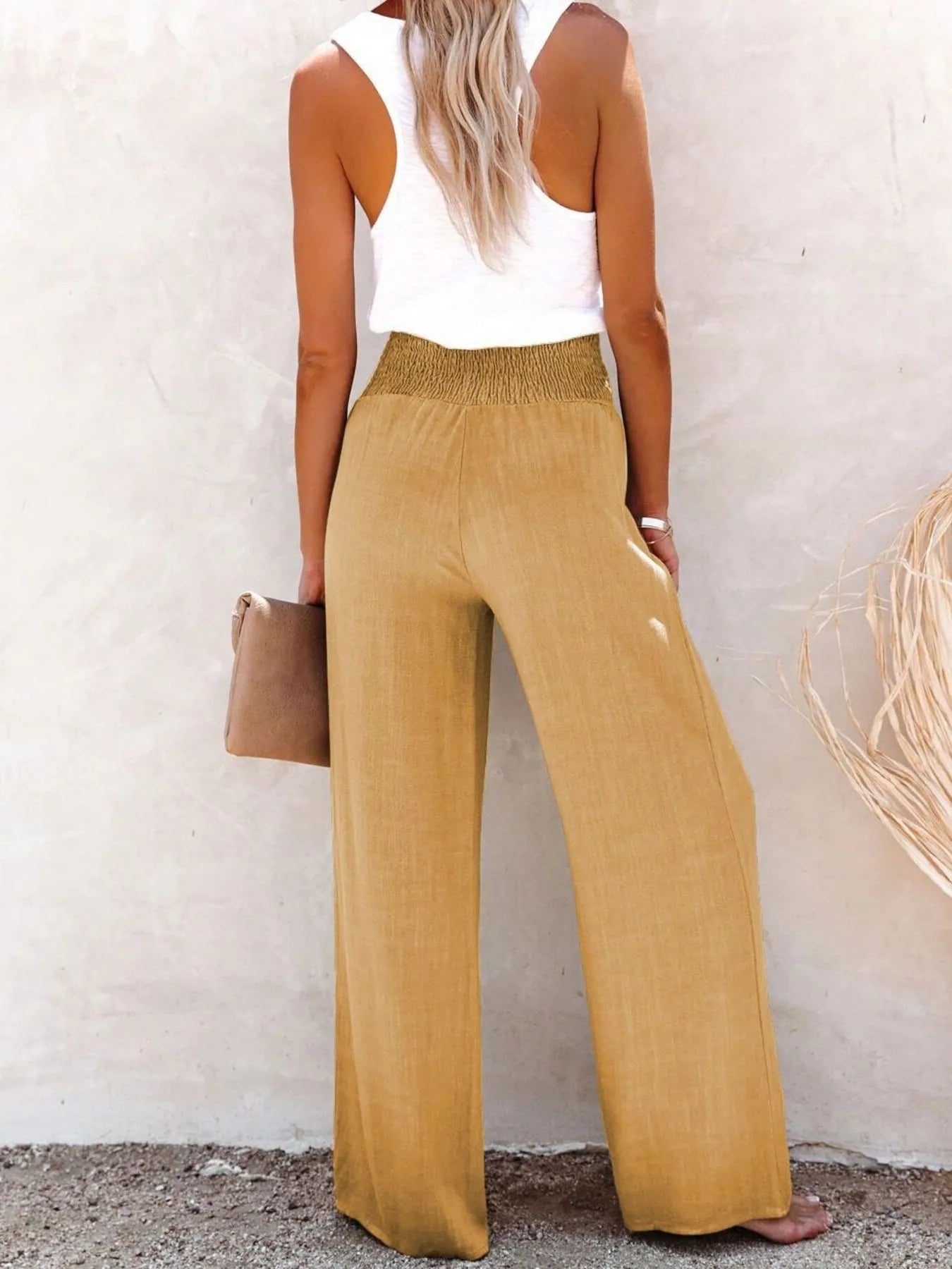 Khaki high-waisted wide-leg pants with textured fabric and smocked waistband