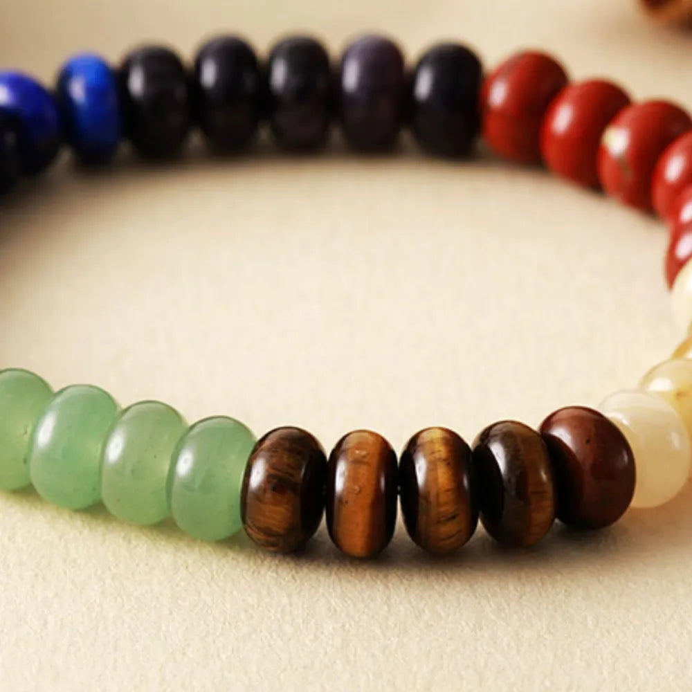 Natural stone bead bracelet close-up with green, brown, black, and cream beads
