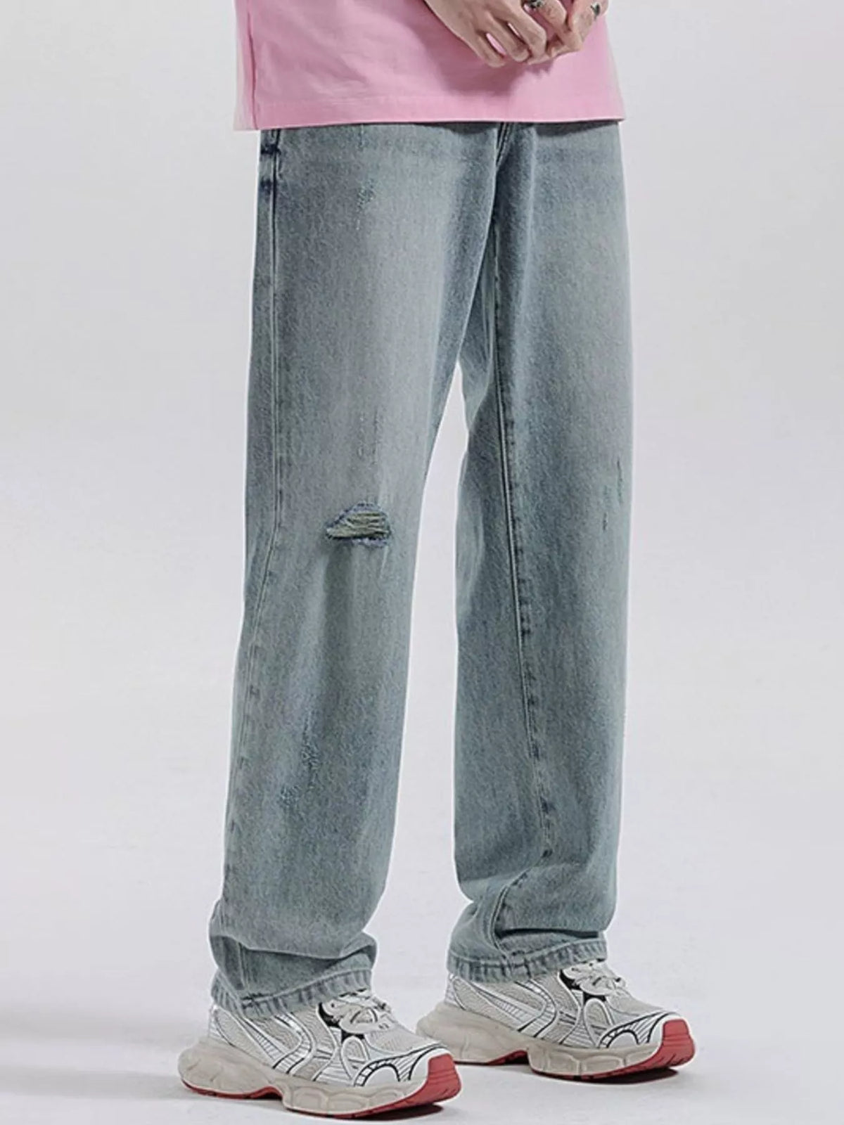 Light blue wide-leg distressed jeans with central ripped knee and relaxed fit