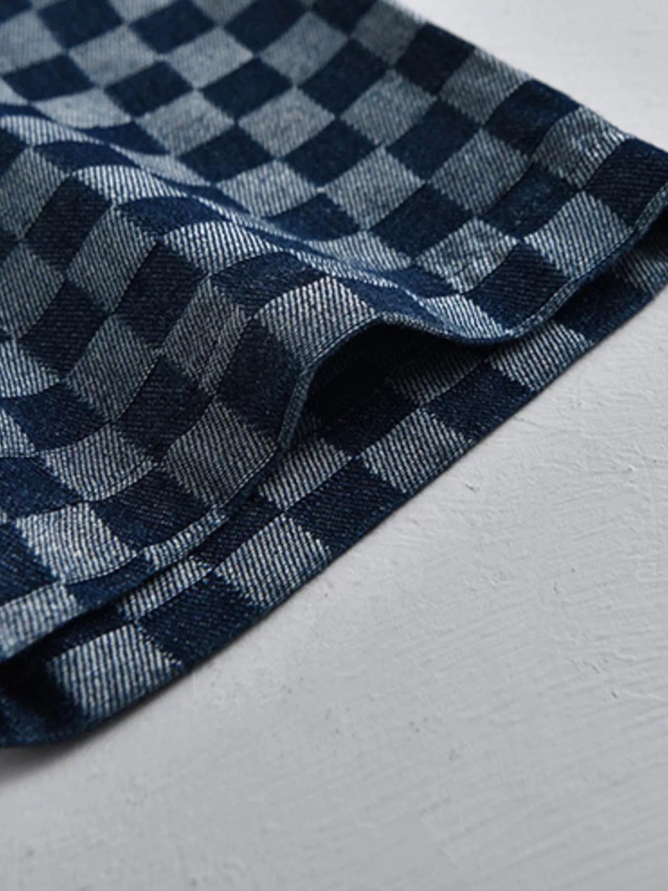 Checkered shirt collar edge detail with folded fabric and dark-blue pattern
