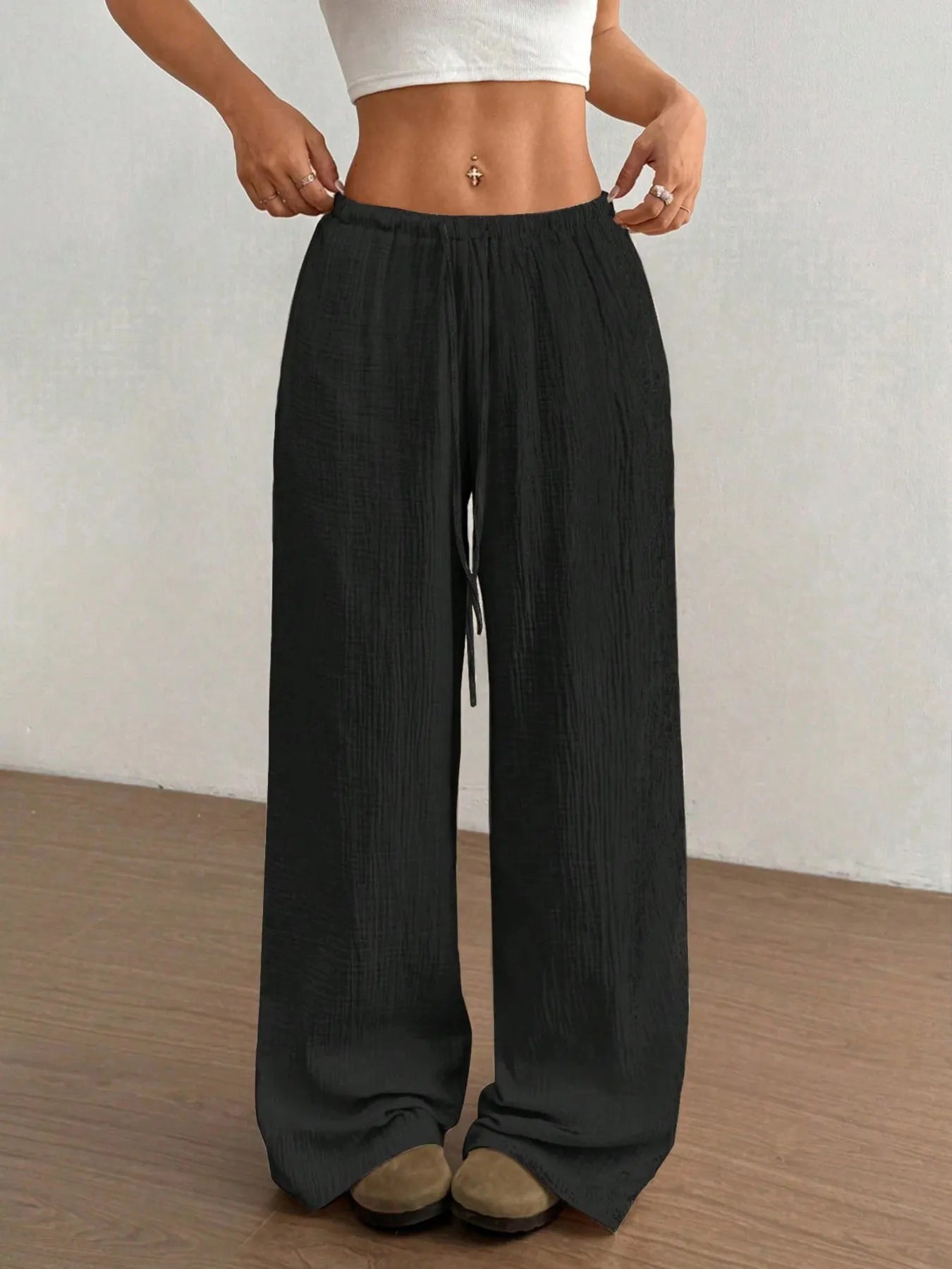 Black wide-leg pants with elastic waist and drawstring, full-length.