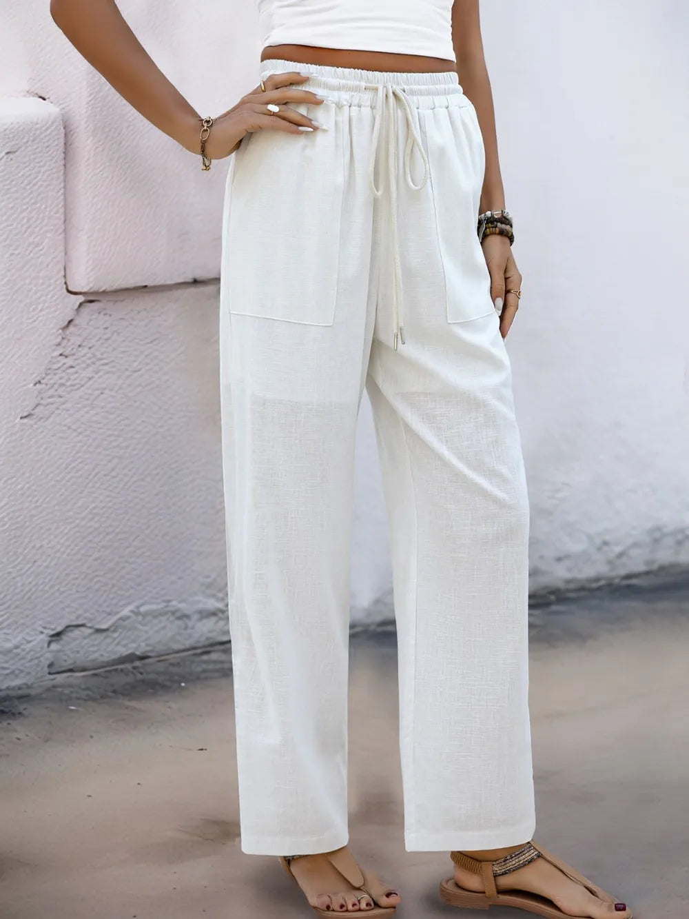 White drawstring pants with elastic waistband and side pockets, wide straight fit