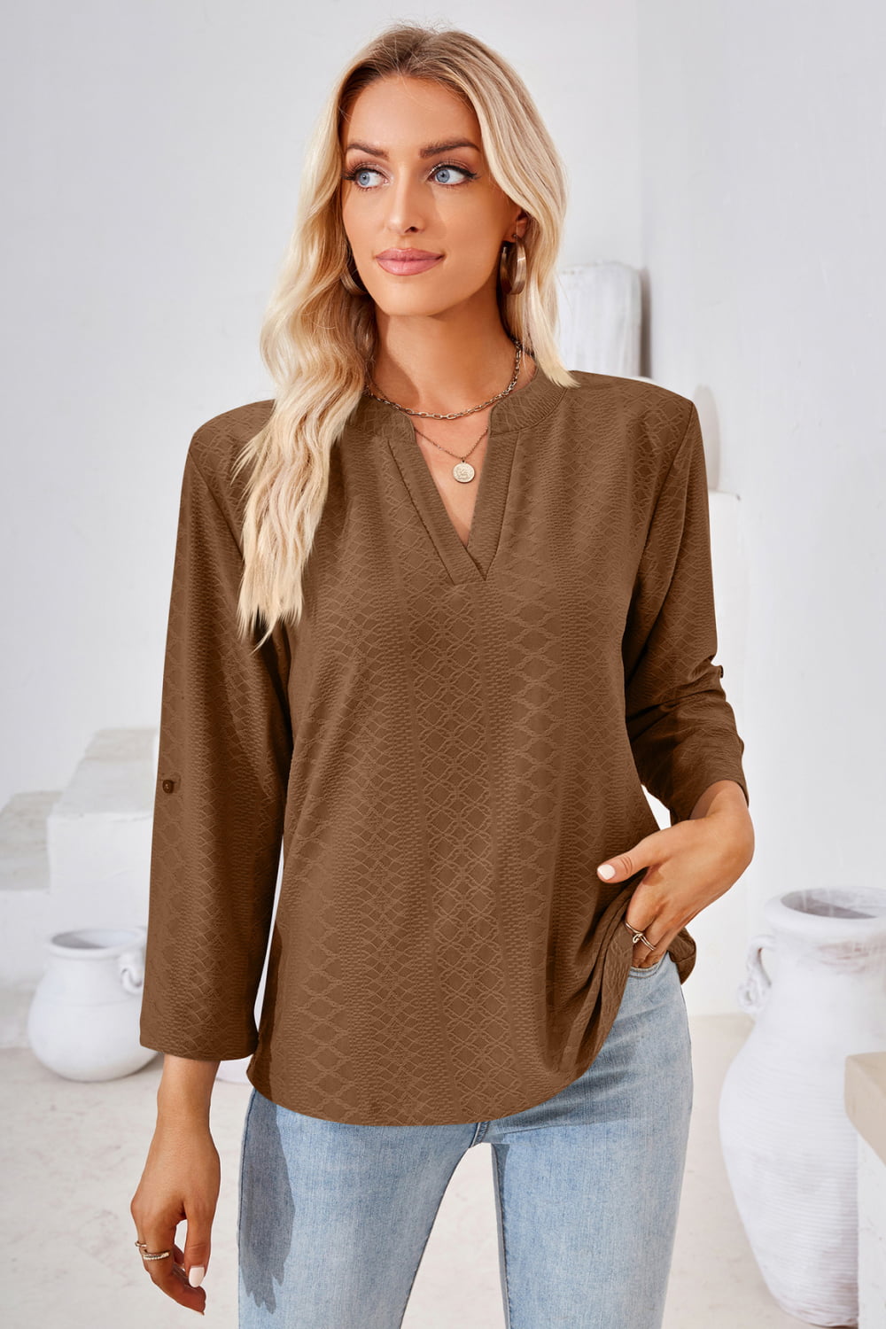 Brown V-neck roll-tap sleeve blouse with textured diamond pattern, three-quarter sleeves