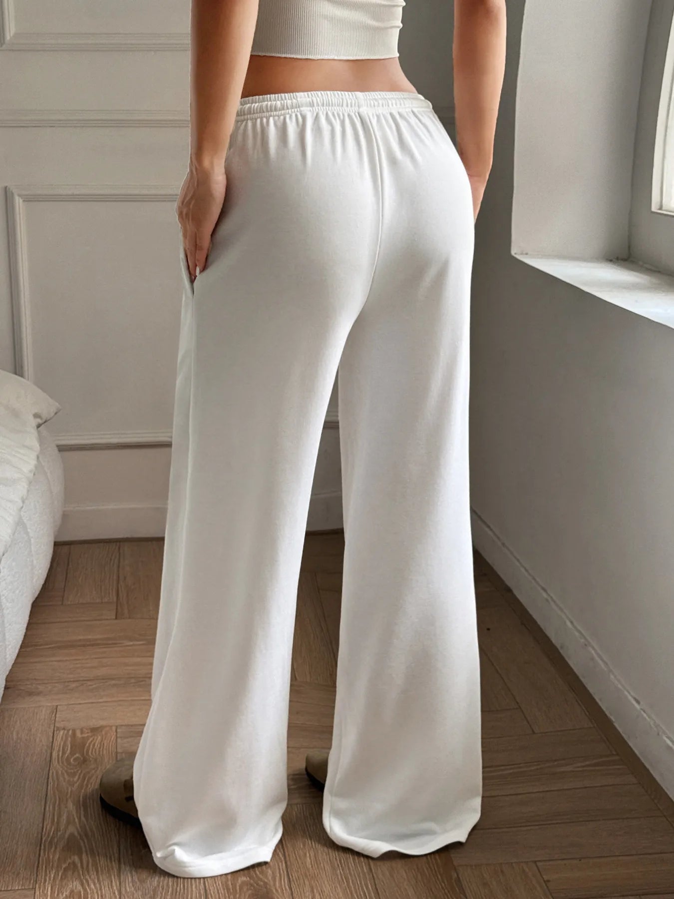 White wide-leg drawstring pants with loose relaxed legs and elastic waistband