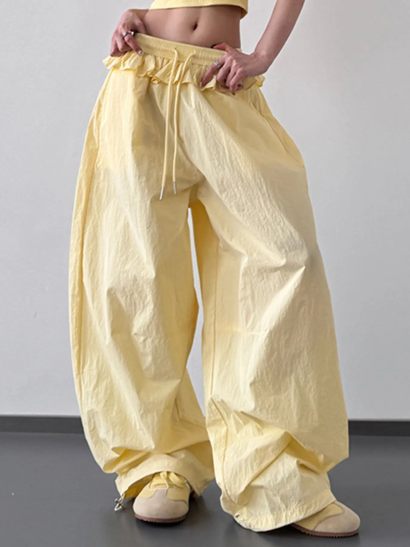 Yellow drawstring wide-leg pants with ruffled waistband, roomy legs, gathered hem