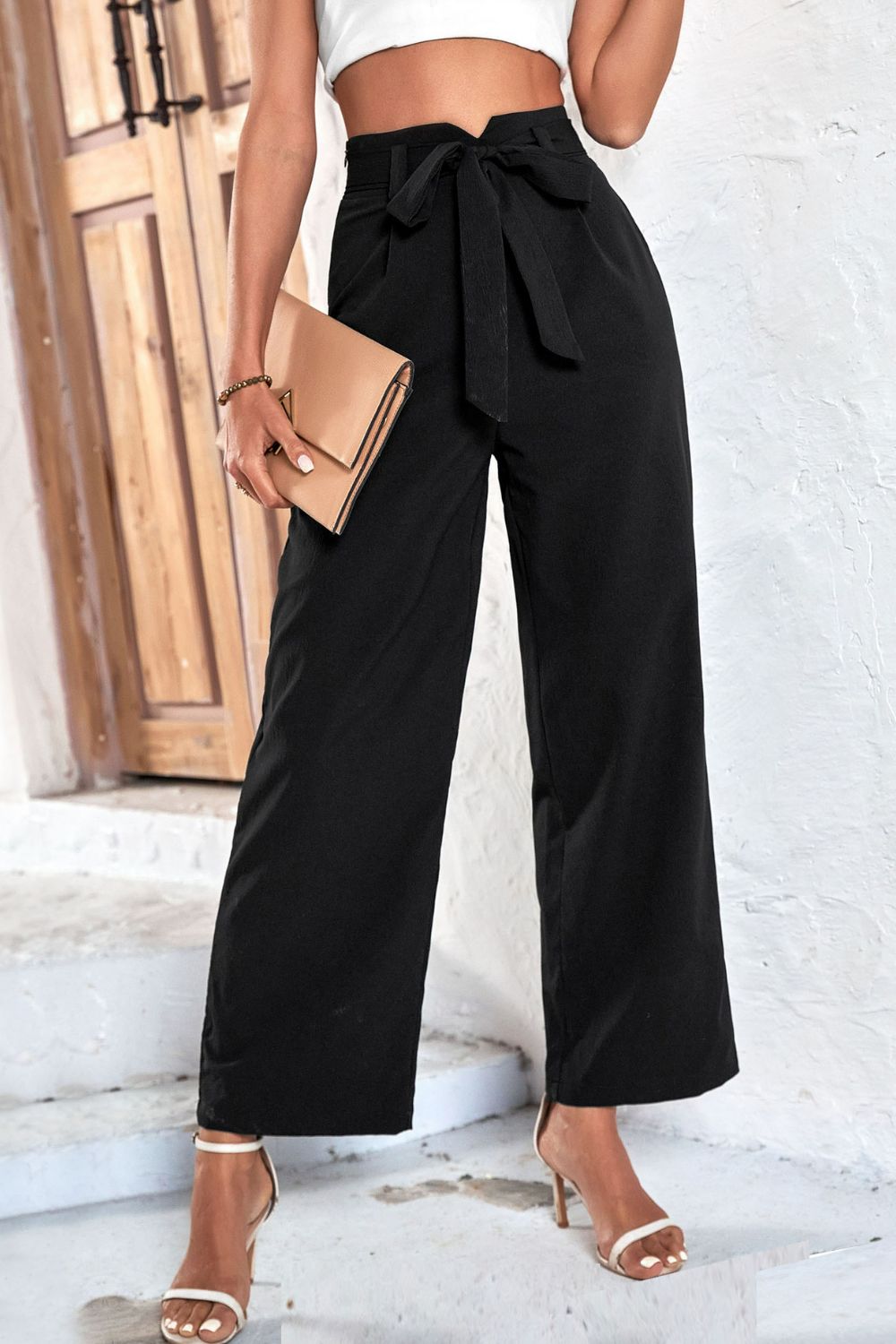 Black belted high-rise wide-leg pants with bow-tie waistband, side view