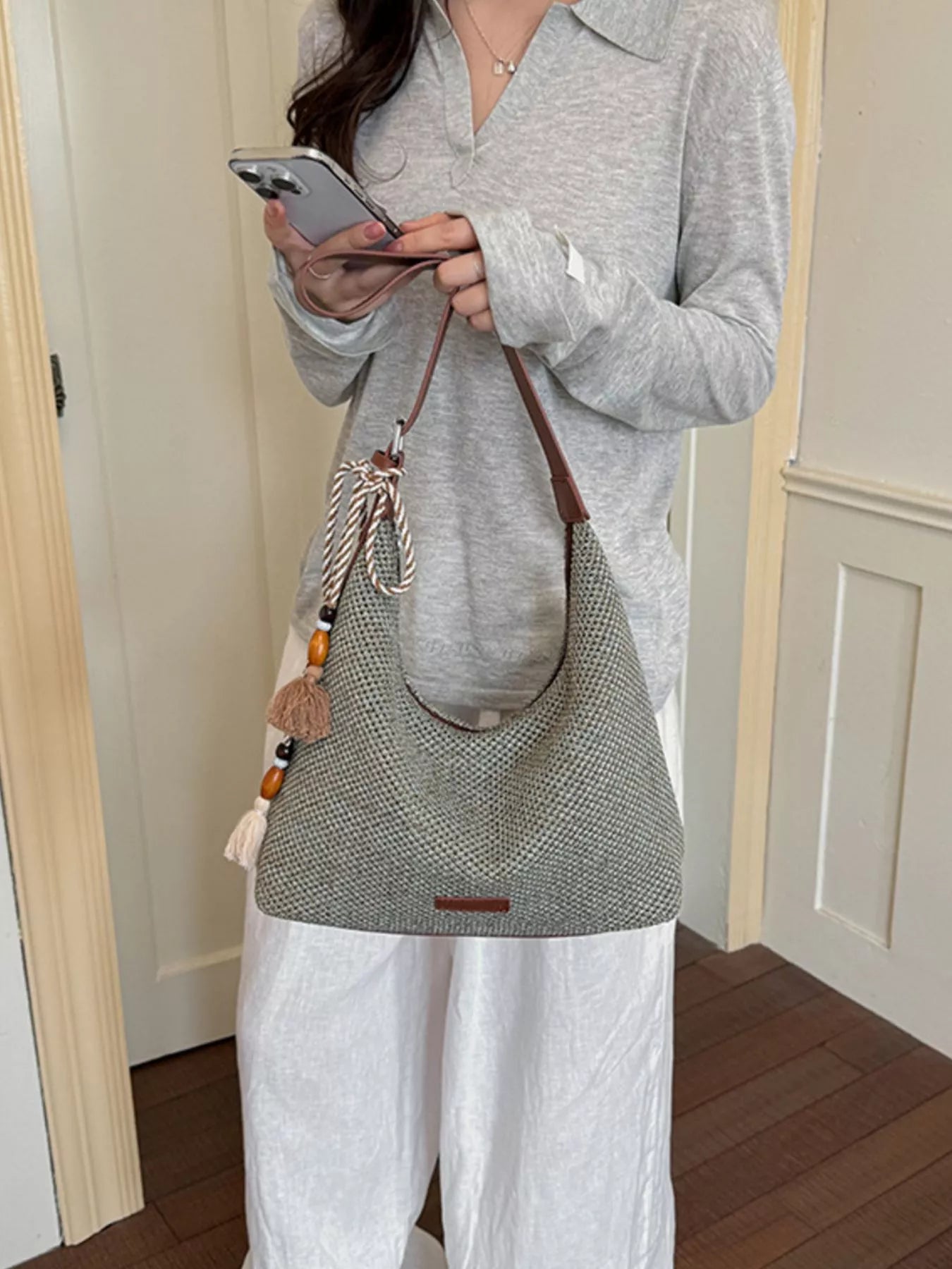 Medium woven shoulder bag with tassel fringe, textured gray weave and brown shoulder strap