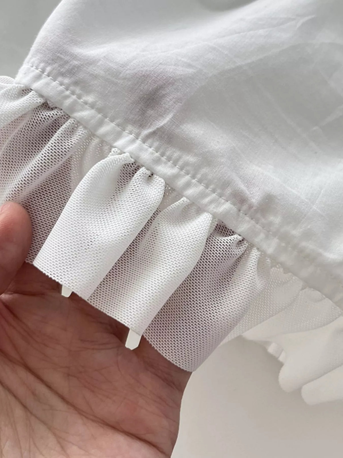 White tiered cotton maxi dress ruffle detail along the hem, with textured layer