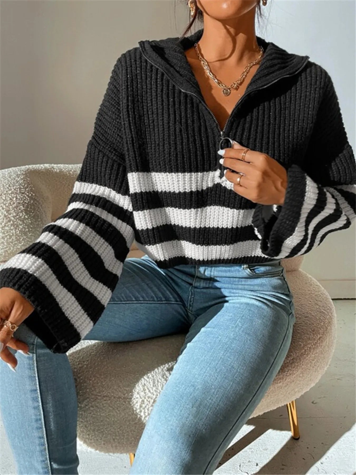 Black cropped half-zip knit sweater with white stripes, center zipper, ribbed cuffs