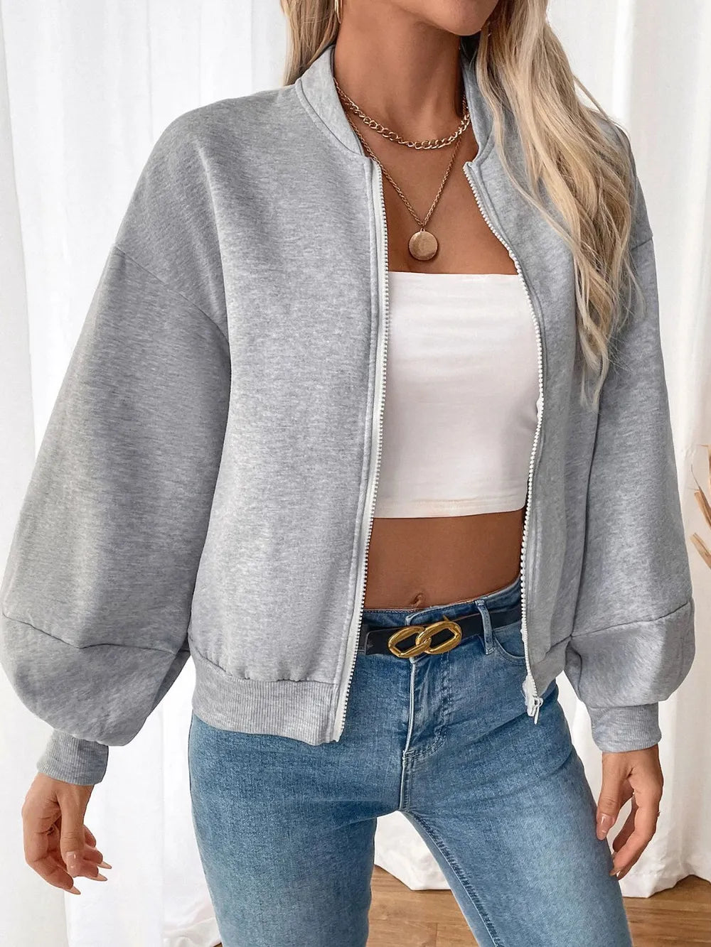Light gray zip-up long sleeve sweatshirt with stand collar and white zipper trim