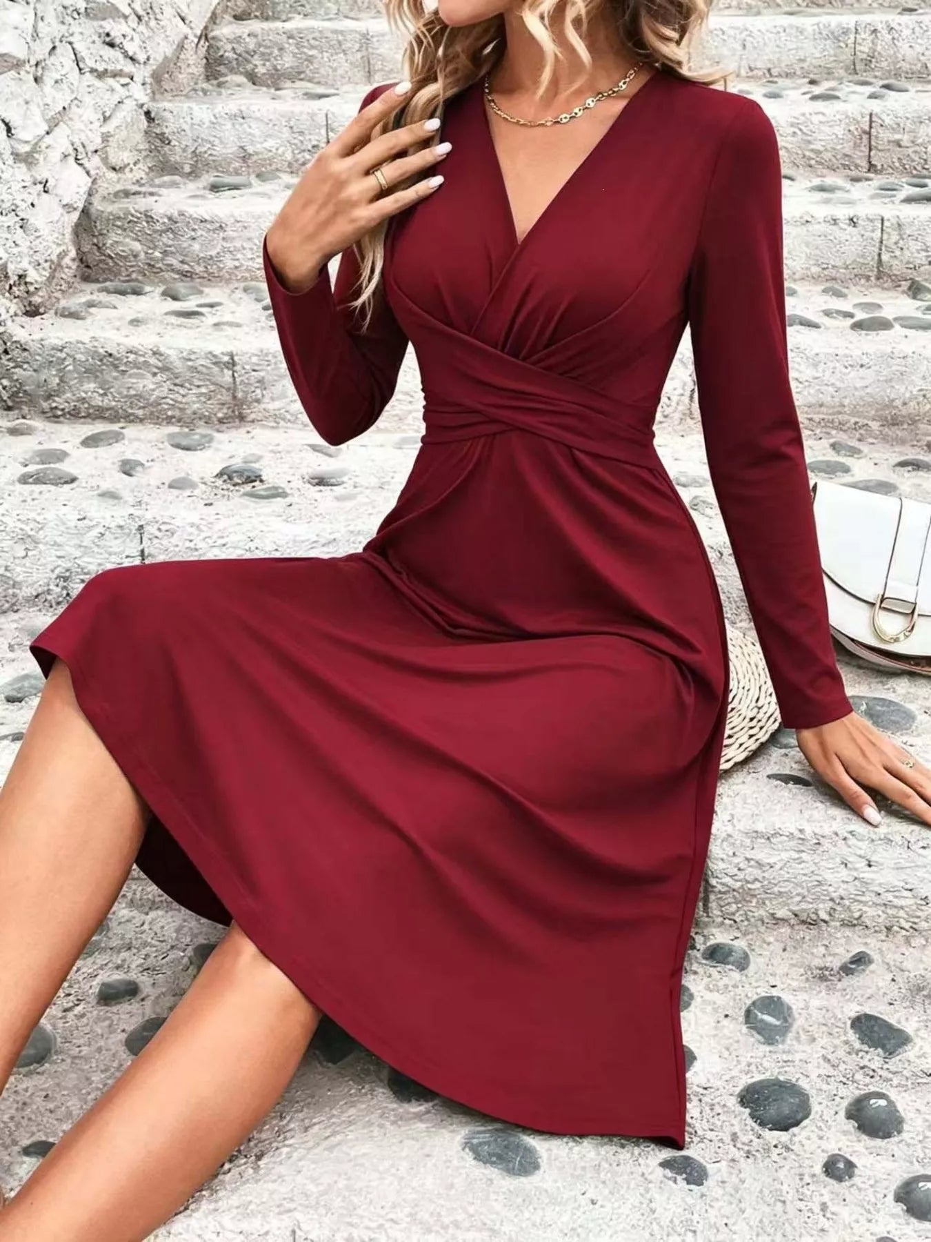 Burgundy long-sleeve surplice midi dress with ruched waist and side drape