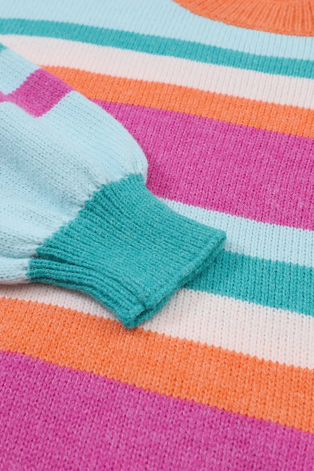 Ribbed sweater cuffs on a multicolor striped knit with teal cuff detail.