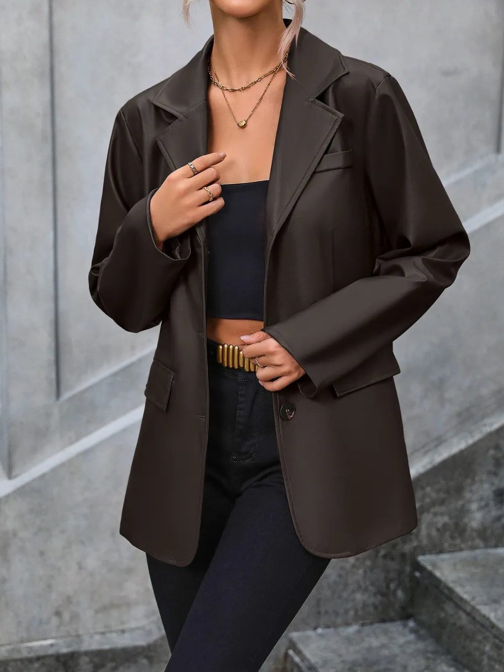Dark button-up blazer with collared neckline, long sleeves, and flap pockets