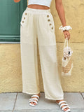 Cream wide-leg pants with front button detail and elastic waistband