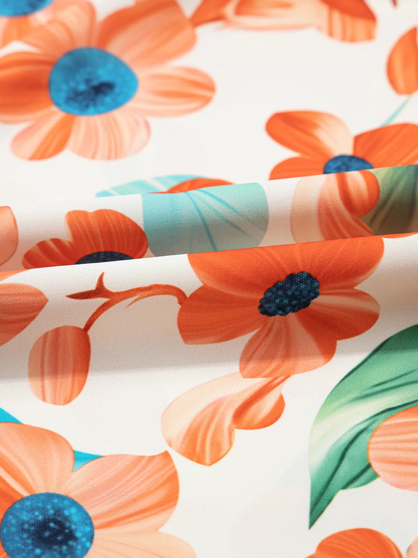 Floral print dress fabric close-up with orange petals and blue centers