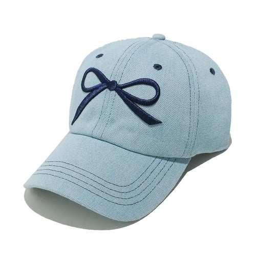 Light blue denim baseball cap with navy bow detail and curved brim