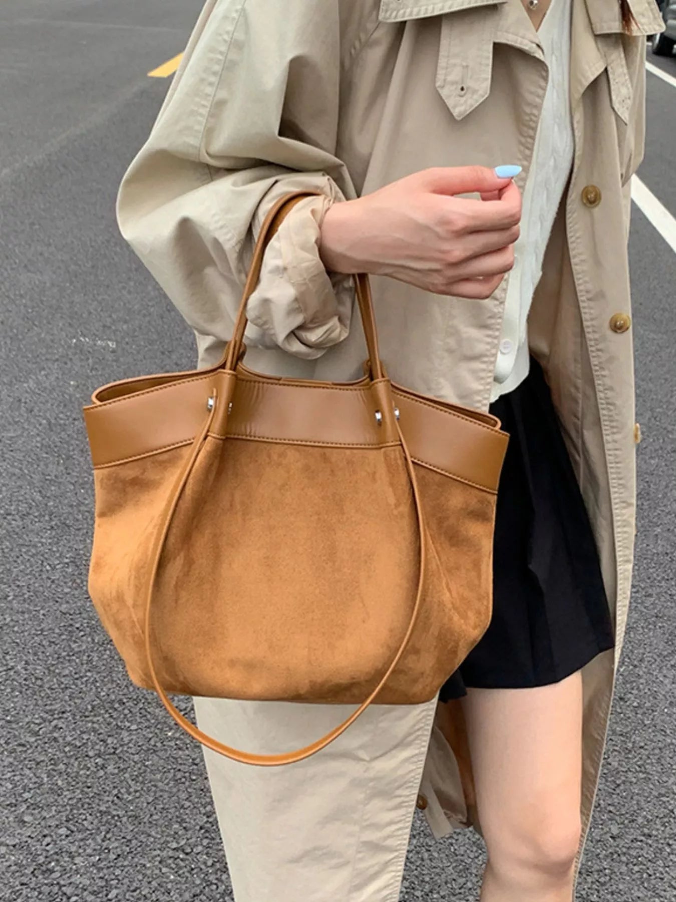 Brown suede shoulder bag with leather handles and a long crossbody strap