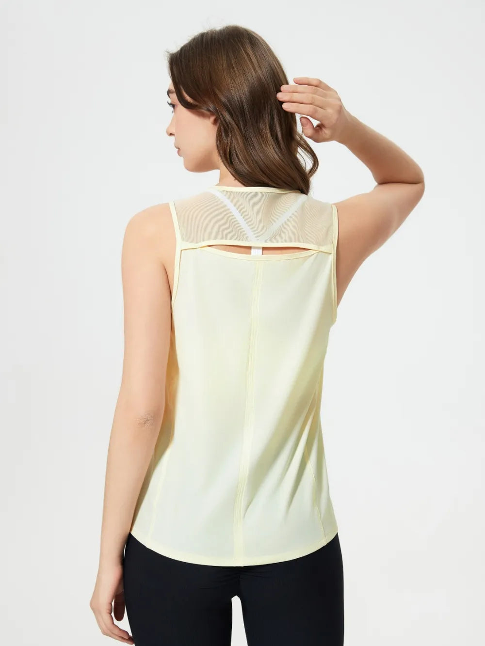 Pale yellow active tank top with cutout back and crisscross strap detail