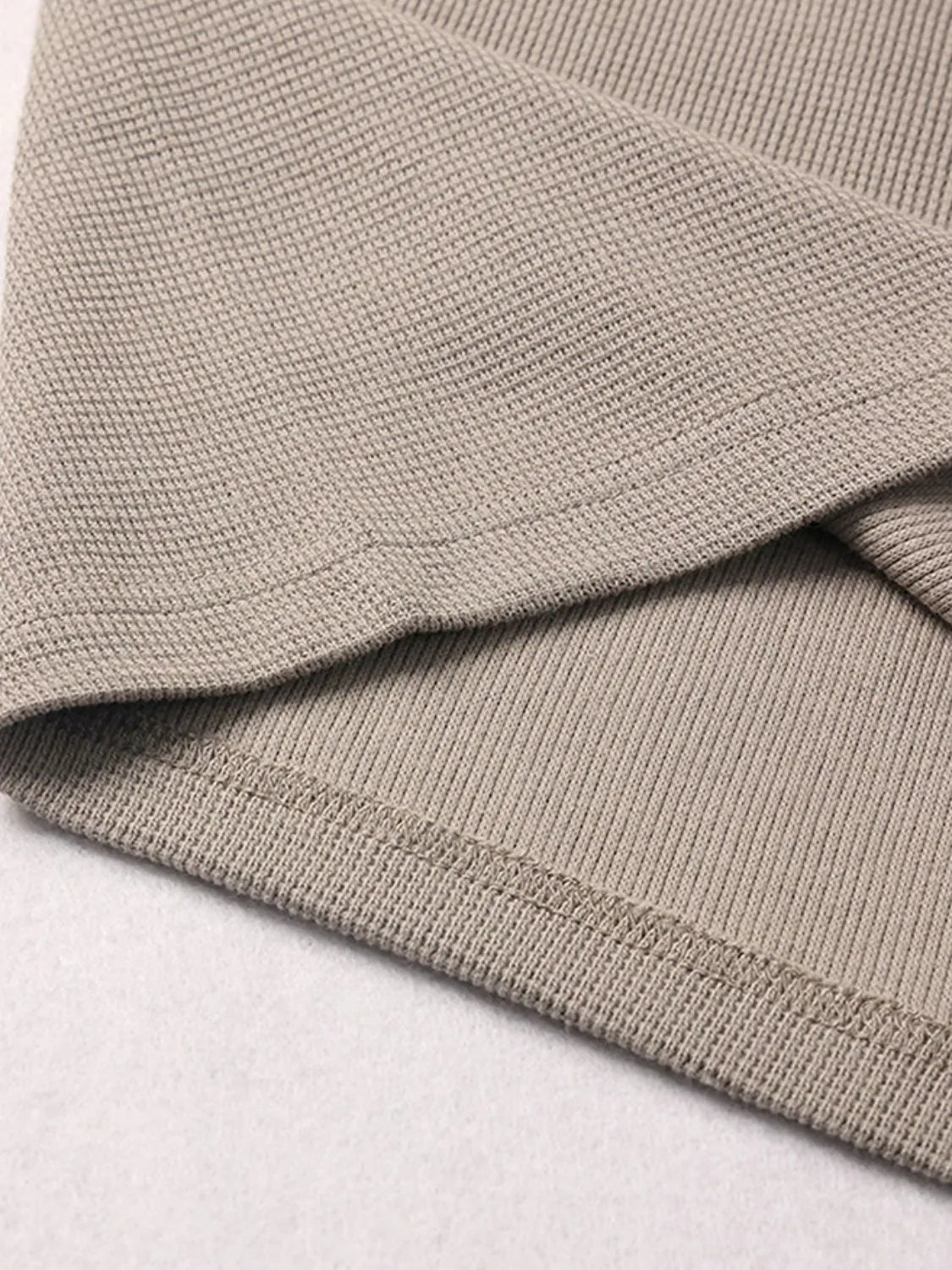 Waffle knit fabric detail on beige drawstring shorts, showing textured pattern and hem.