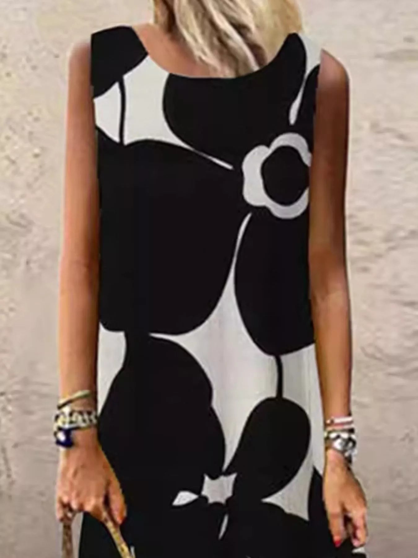 Black sleeveless maxi dress with large floral print, fitted bodice and straight skirt