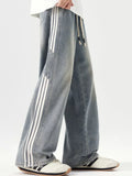 Washed blue wide-leg jeans with drawstring waist and side stripe detail