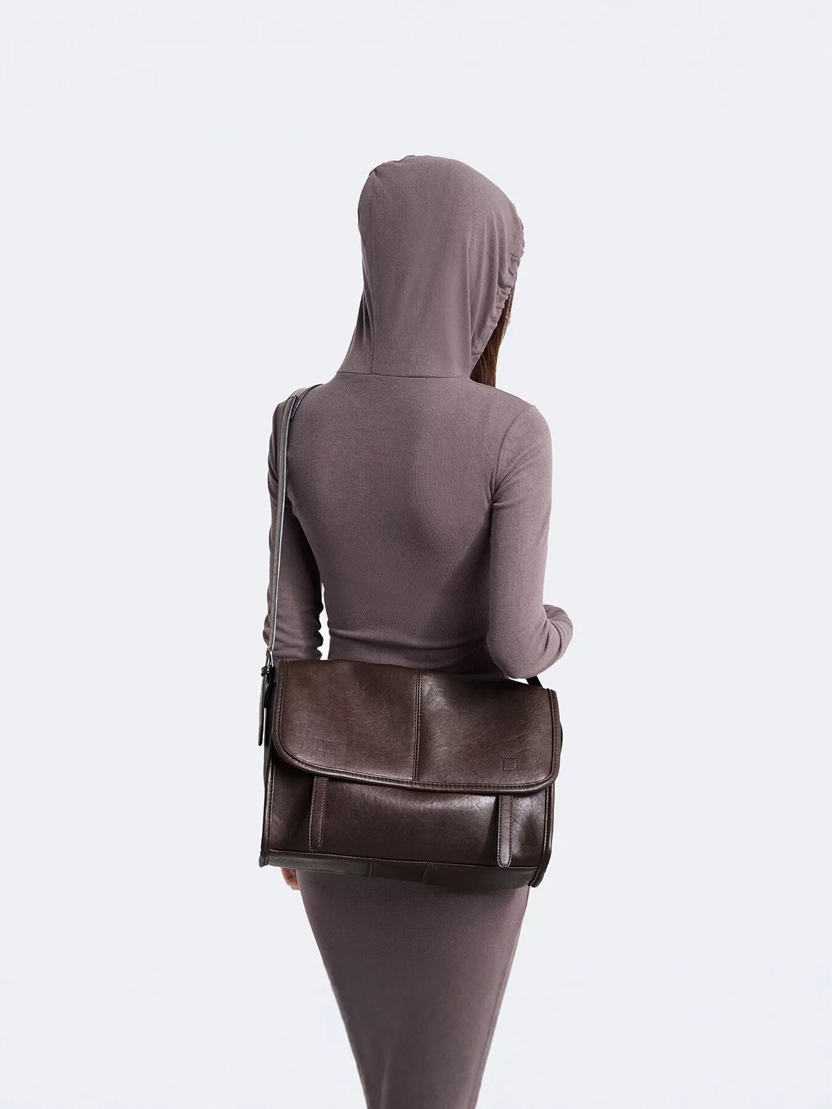 Brown vegan leather medium messenger bag shown from back with flap and strap