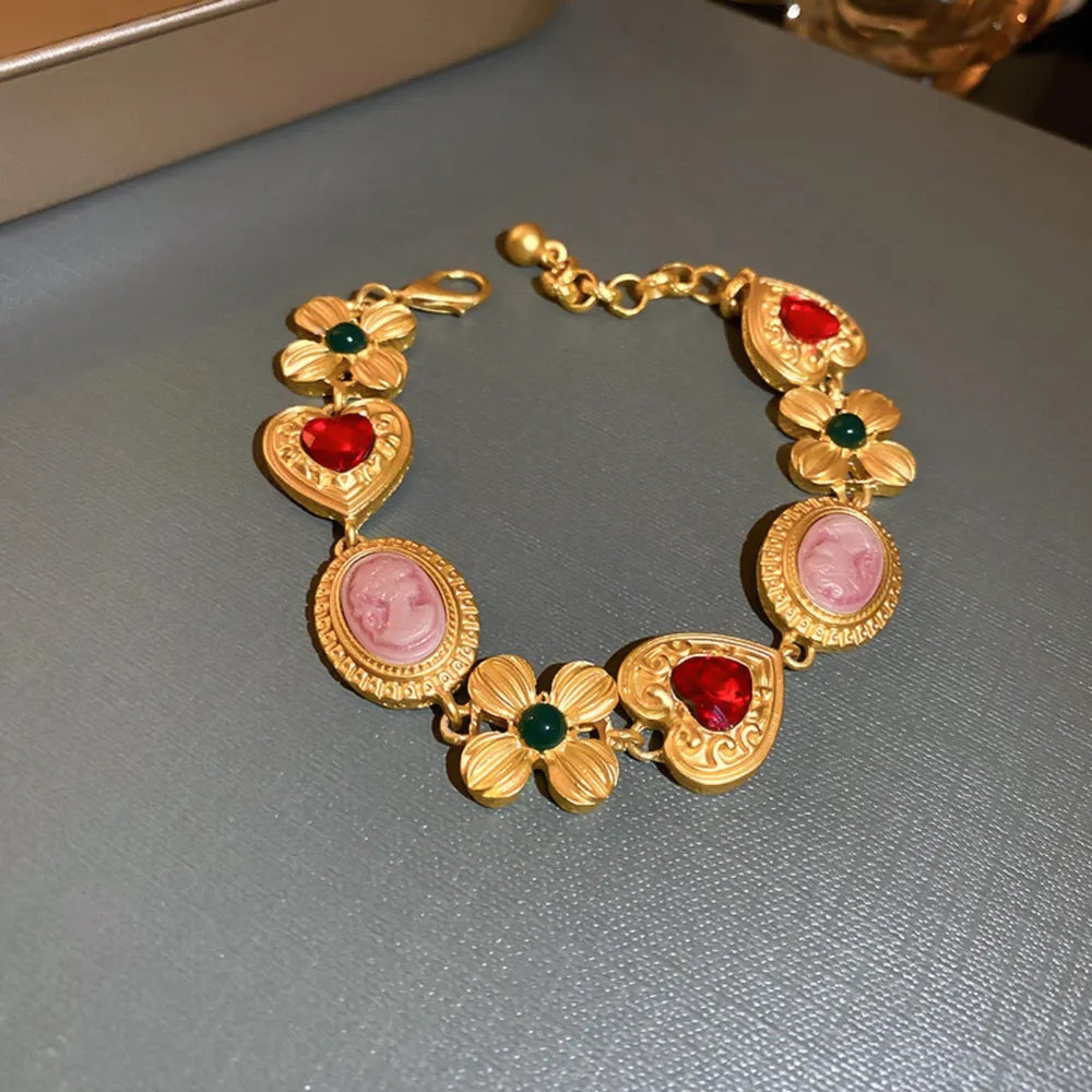 Gold-tone vintage charm bracelet with red heart and pink oval rhinestone links