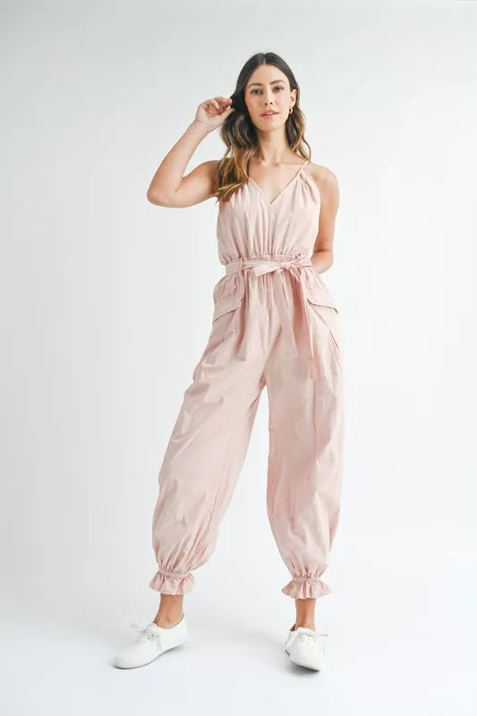 Pink spaghetti strap jumpsuit with tied waist and billowy gathered cuffs