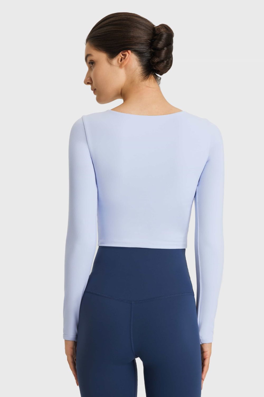 Light blue long-sleeve cropped sports top, back view with waist cutout