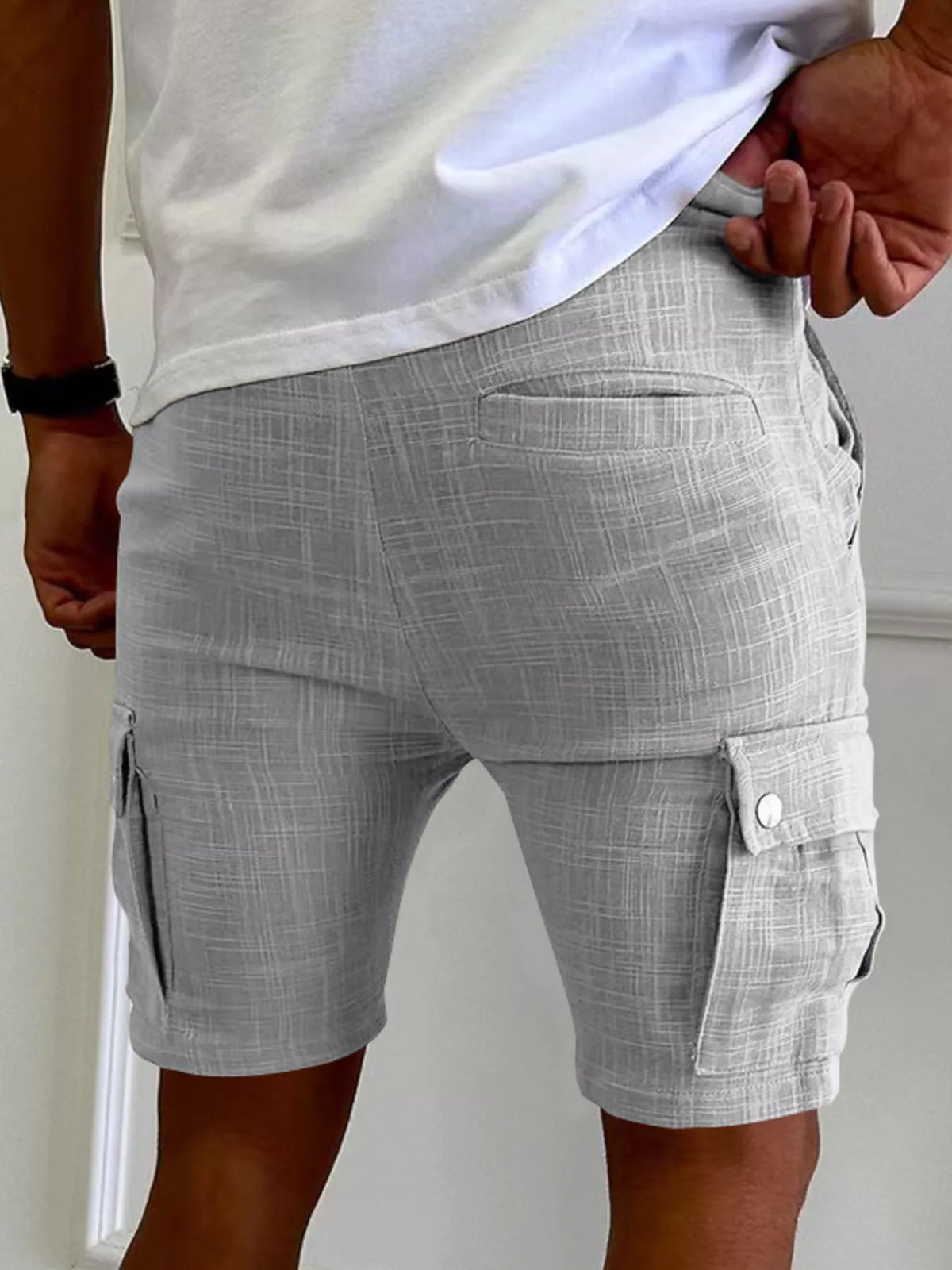 Men’s light gray cargo shorts with side cargo pocket and buttoned flap at lower hem.