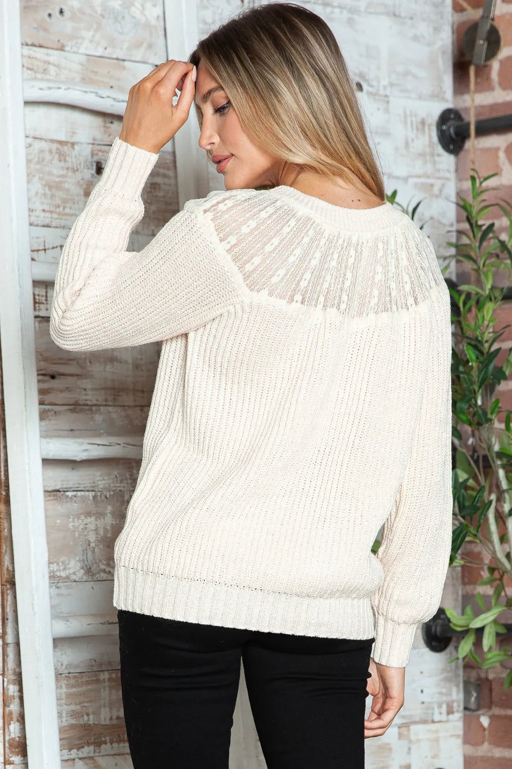 Cream rib-knit sweater from back view with textured yoke stripe detail and ribbed cuffs