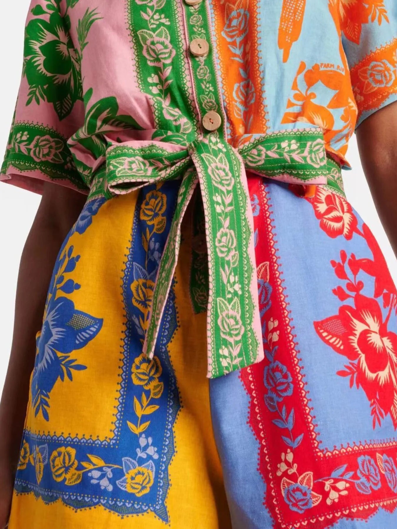 Multicolor printed romper close-up of tied waist belt and buttoned collar