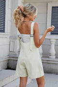 Adjustable-strap V-neck romper in light beige, with short legs and back tie detail.