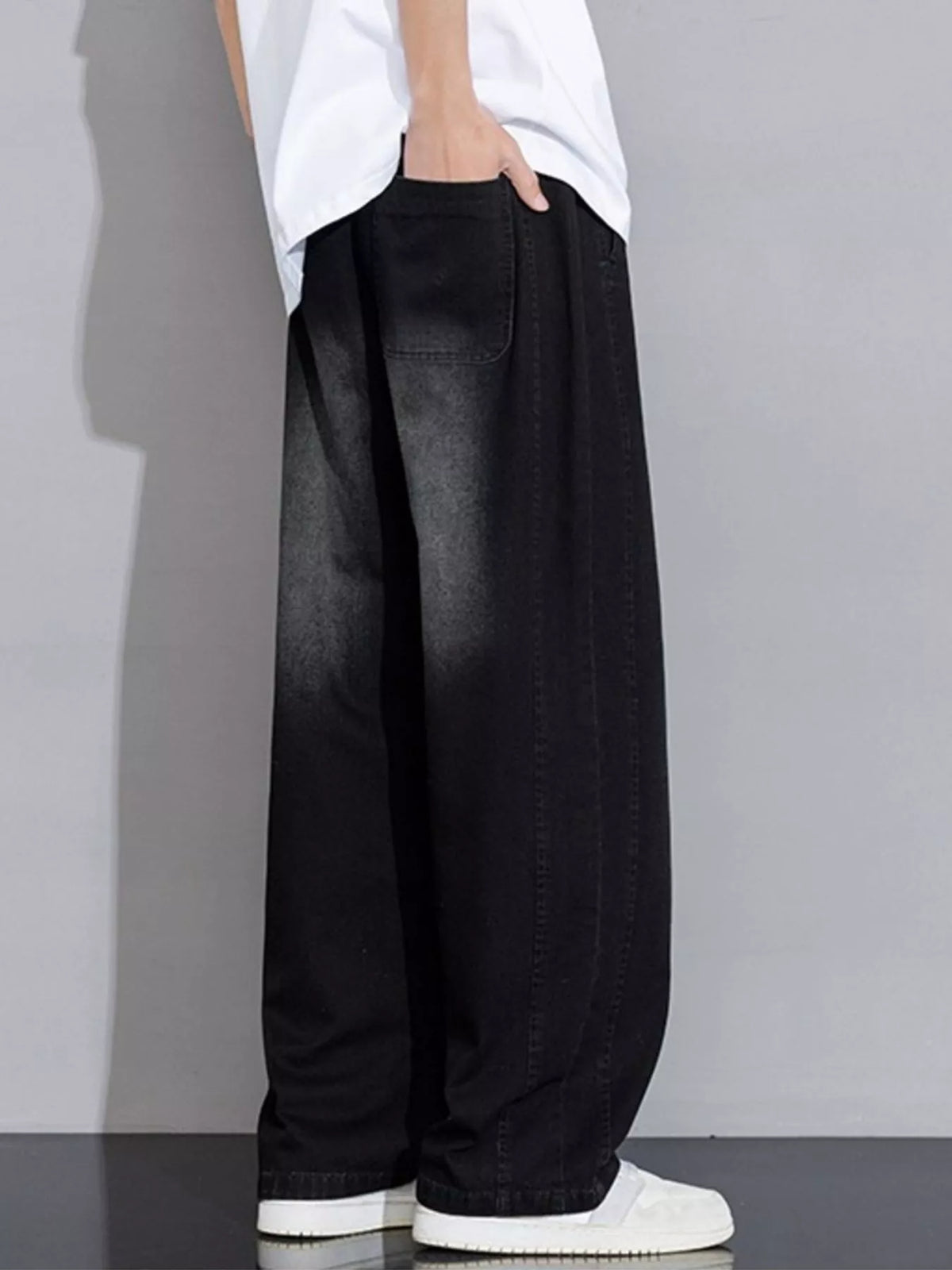 Men's black wide-leg drawstring jeans with subtle stitching and back patch pocket
