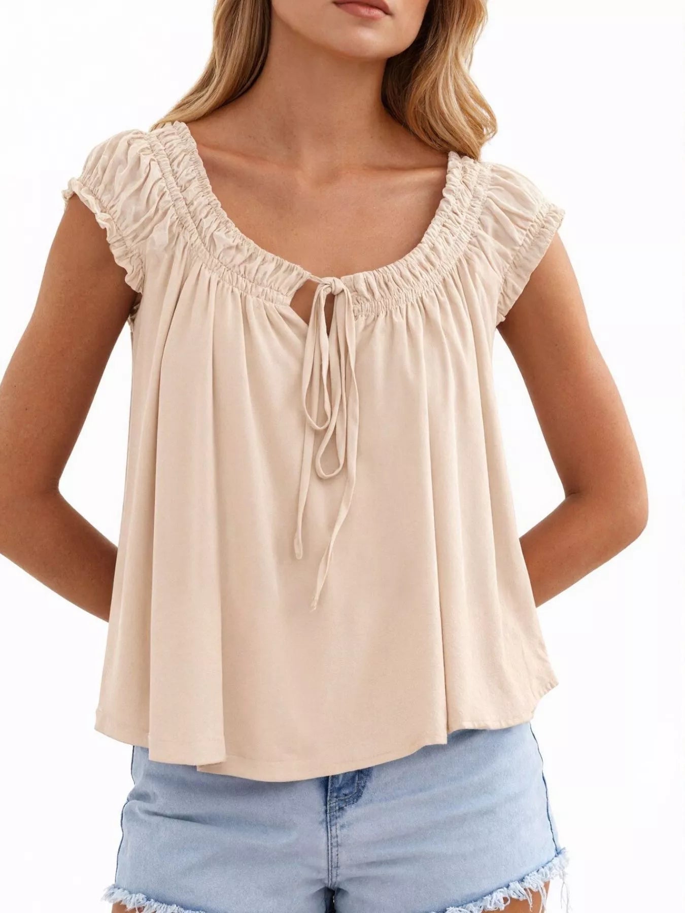 Cream tie-front blouse with ruffled cap sleeves and center drawstring tie at neckline