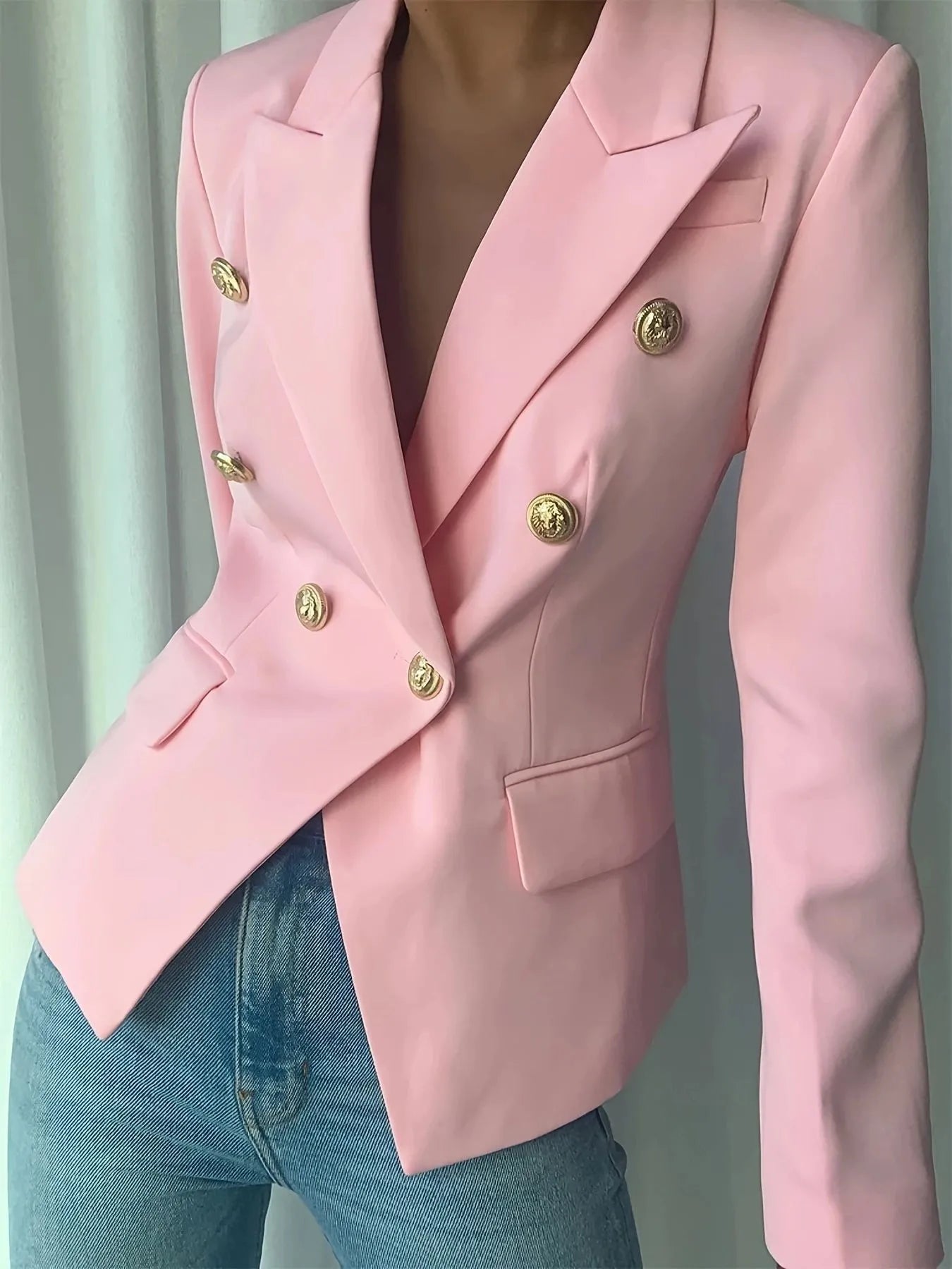 Pink blazer with notch lapel, gold decorative buttons, and flap chest pockets