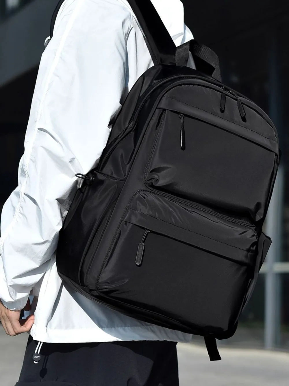 Black multi-pocket backpack with front zip compartment and adjustable shoulder straps