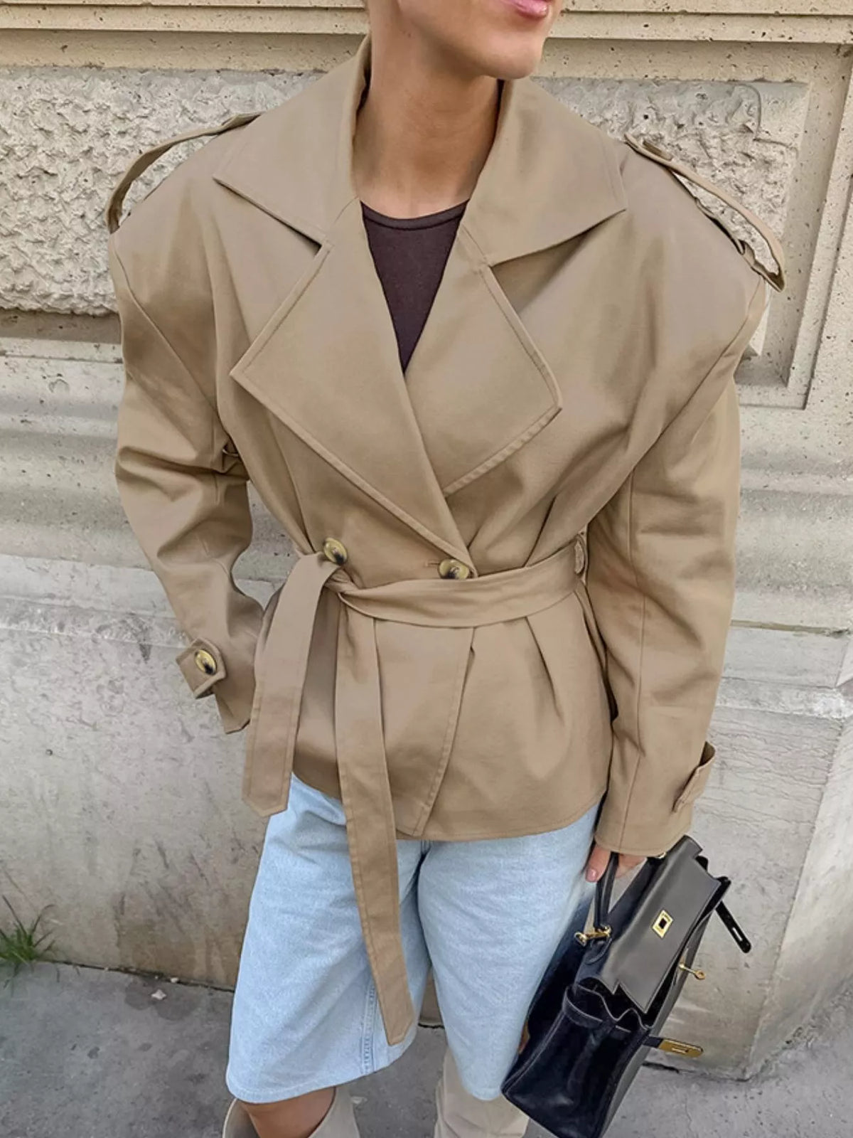Khaki double-breasted belted trench coat, 3/4 view with gold buttons and shoulder epaulets