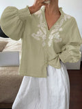 Light green embroidered long sleeve blouse with V-neck and button front, puff sleeves