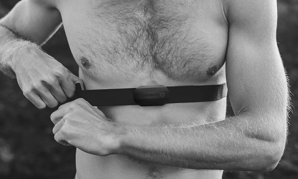 Black chest strap heart rate monitor worn on a man’s upper torso