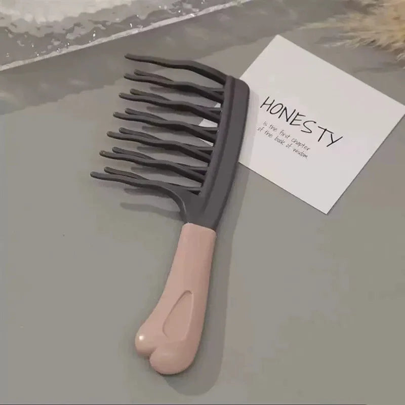 Dark grey wide-tooth detangling comb with long prongs and beige handle, on card
