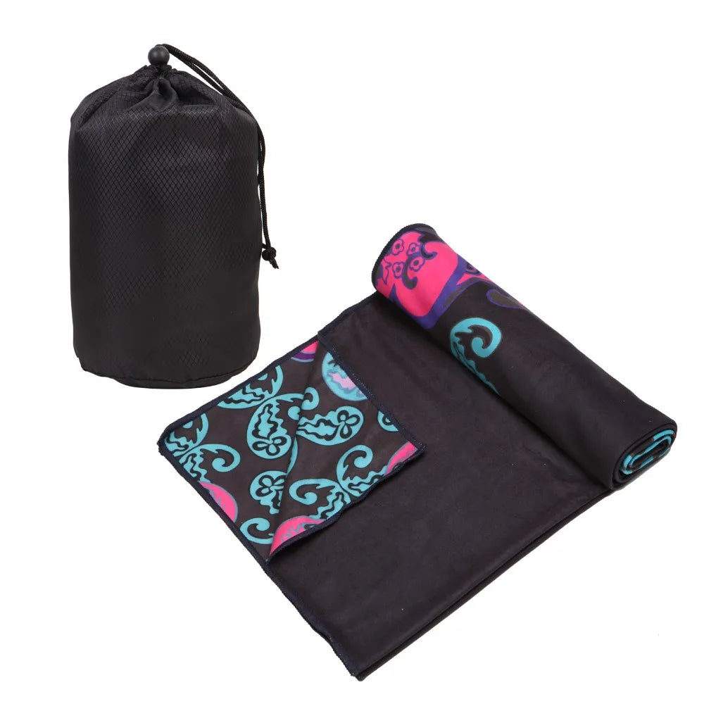 Black yoga mat towel folded with hot pink and teal patterned trim