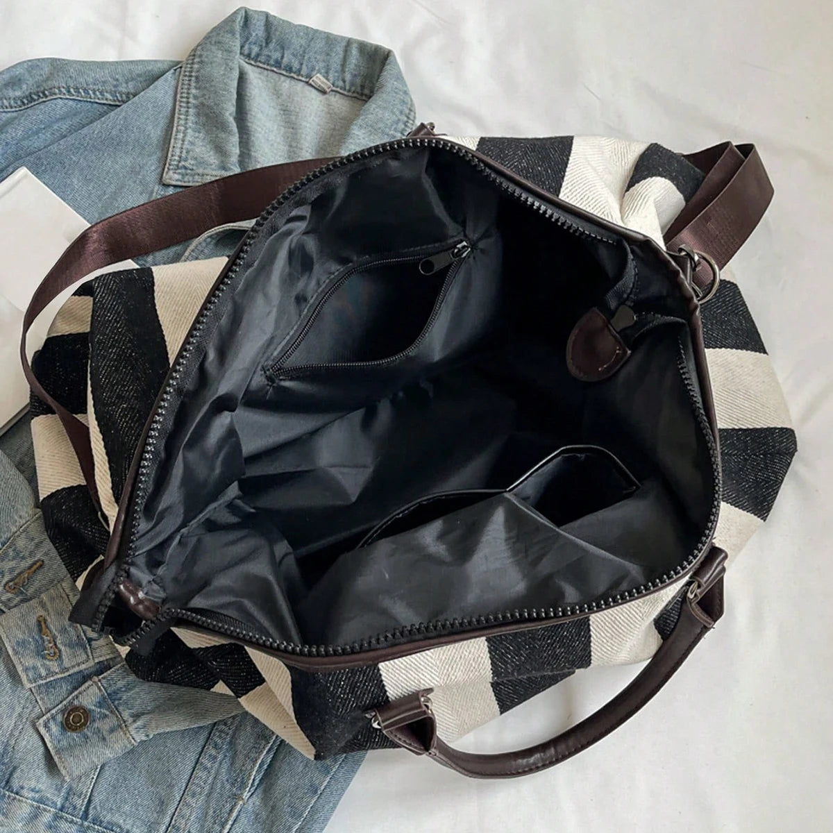 Open striped duffle bag interior with zip opening and organizer-style compartments