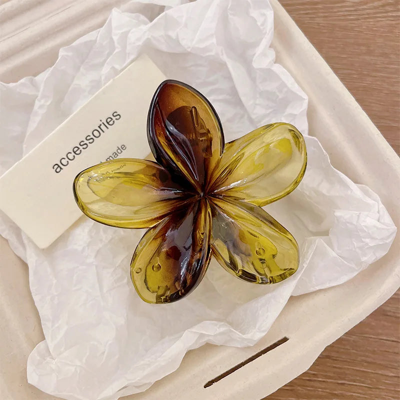 Amber and gold flower hair claw clip with glossy five-petal petals and plastic barrette