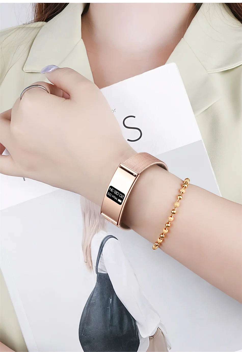 Rose gold fitness tracker bracelet on wrist with rectangular OLED display